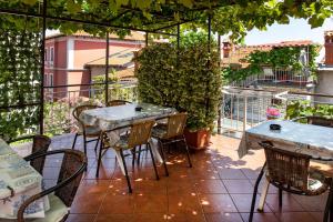 a patio with tables and chairs on a balcony at Apartmaji pri Perotu in Izola