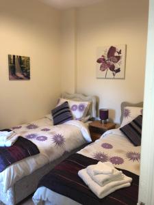 a bedroom with two beds and a table at Gilmore House in Ardglass