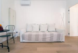 un letto bianco con quattro cuscini in una stanza di Alex Suite a Como