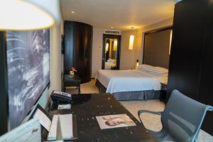 a hotel room with a bedroom with a bed and a desk at Barceló Mexico Reforma in Mexico City