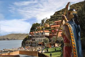 a statue of a man with a spear in front of a mountain at Gloria Copacabana in Copacabana