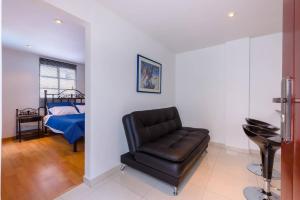 sala de estar con silla de cuero y cama en LOFT APARTMENT IN CENTRAL LOCATION (301), en Bogotá