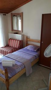 a bedroom with a large bed and a window at HOUSE DILENA TSIMTSIRI in Limenaria