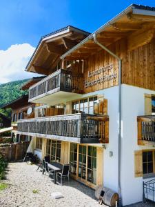 a building with balconies and tables and chairs at Landhaus Bergglühen inkl Bergbahnticket in Oberjoch
