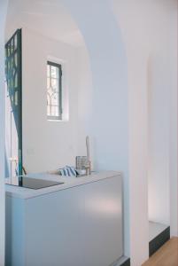 un bagno bianco con lavandino e specchio di Alex Suite a Como