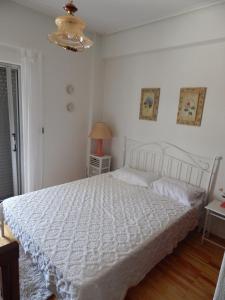 a bedroom with a white bed and a lamp at Zira Holiday House in Makrýgialos