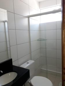 Baño blanco con aseo y lavamanos en Hotel Lisboa en Curitiba