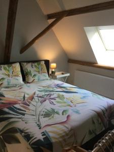 a bedroom with a bed with a colorful comforter and a window at De Hocht in Nes