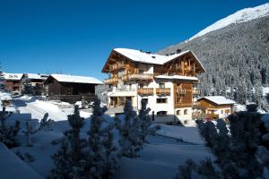 um grande edifício na neve com neve em Hotel Vedig em Santa Caterina Valfurva