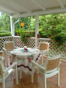 una mesa blanca y sillas en un porche en Csilla Haus, en Bük