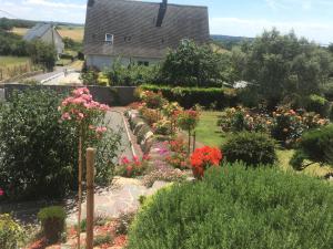 a garden with flowers and a building in the background at Les Balcons de Saint Pair in Saint-Pair-sur-Mer