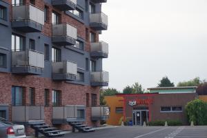 a tall apartment building with balconies and a parking lot at Apartment Dolfi, Senec in Senec