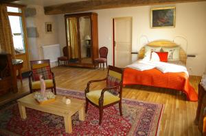 a bedroom with a bed and a table and chairs at Chambre d'hôtes de Pirieuc in Meillac