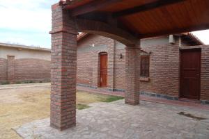 a brick house with a brick pillar and a wooden door at Cabañas Inti Killa (MR) in Cachí