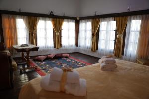 a room with two towels on a bed with windows at Guest House Mikel in Berat