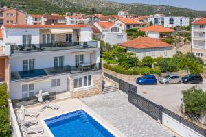 een villa met een zwembad en een parkeerplaats bij Apartment Apollo 3 in Trogir