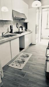 a kitchen with white cabinets and a rug on the floor at A un Passetto dal Conero in Ancona