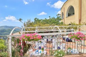 einen Balkon mit Tischen, Stühlen und Blumen in der Unterkunft Palazzo Gentilcore in Castellabate