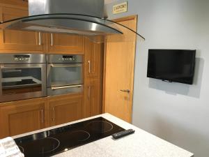 a kitchen with a stove and a flat screen tv at No 14 in Portsmouth