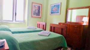 a bedroom with two beds and a dresser and a mirror at A un Passetto dal Conero in Ancona