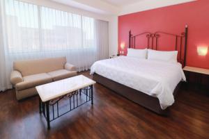 a hotel room with a large bed and a couch at Holiday Inn Hotel & Suites Centro Historico, an IHG Hotel in Guadalajara