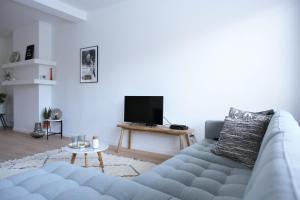 a living room with a couch and a tv at Brygga in Bruges