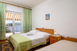 a bedroom with two beds and a balcony at Apartments VV in Seget Vranjica