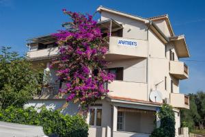 a building with purple flowers on the side of it at Apartments Bilja - 20 M from the sea in Rogoznica