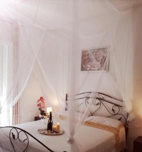 a white bedroom with a bed with a canopy at Gio.Ele in Melendugno
