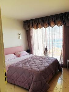 - une chambre avec un lit et une grande fenêtre dans l'établissement La terrazza di monaco, à Cap d'Ail