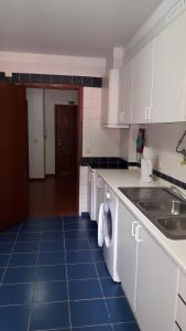 Il comprend une cuisine avec des placards blancs et du carrelage bleu. dans l'établissement Apartamento Capela, à Funchal