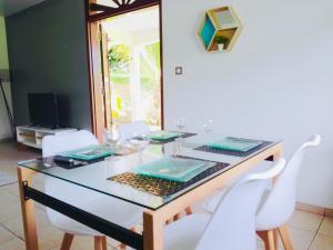 BourdaMaison sur la côte - jusqu'à 4 personnes的配有玻璃桌和白色椅子的餐厅