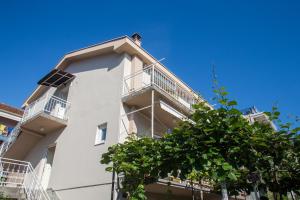 a white building with balconies and a blue sky at DiVino Apartment in Tivat