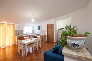 ein Wohnzimmer mit einem Tisch und Stühlen sowie eine Küche in der Unterkunft Casa Vacanza AZZURRA in Cinisi