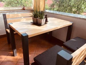 a wooden table with a potted plant on a balcony at Rooms Jana in Slunj