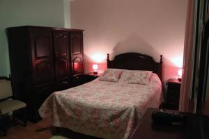 um quarto com uma cama e uma cómoda em madeira em Casa reizinho em Santana