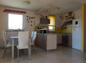 a kitchen with a table and a white refrigerator at Apartment Porozina, Cres in Cres