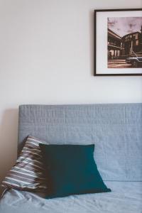 een bed met een blauwe deken en een foto aan de muur bij Comfy & Relaxing Apartment in Thessaloniki