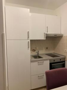 a white kitchen with a sink and a refrigerator at Villa Saline Apartments Portorož in Portorož