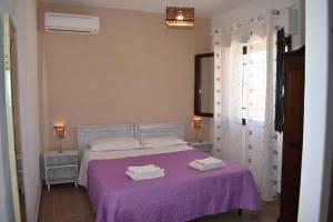 a bedroom with a purple bed with towels on it at Da Mesciu Nzinu in Sannicola