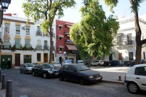 eine Gruppe von Autos, die auf einer Stadtstraße geparkt sind in der Unterkunft Pension Perez Montilla in Sevilla