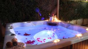 Le Ville della Contea -Vacation rentals في ماسكالي: حوض استحمام ساخن مع أضواء في الفناء الخلفي مع مقبلات