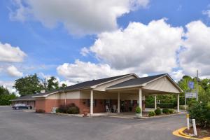 een gebouw met een auto geparkeerd op een parkeerplaats bij The Heritage Inn, Inc in Huntingdon
