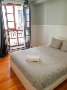 Un dormitorio con una cama con una toalla. en Pension Aussie Guesthouse, en San Sebastián