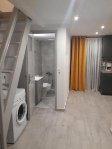 a bathroom with a washer and dryer in a room at Asterias in Skiros