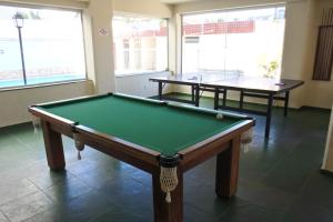 a pool table in a room with two tables at Apto praia Martim de Sá in Caraguatatuba
