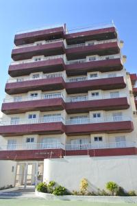 un edificio alto con balcones a un lado. en Apto praia Martim de Sá, en Caraguatatuba