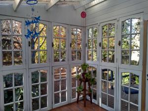 um quarto com janelas grandes e portas brancas em Villa Ocampo em Tigre