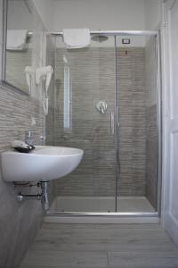 a bathroom with a glass shower and a sink at Villa Ada in Santa Domenica