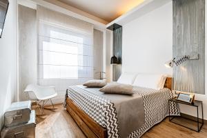 1 dormitorio con 1 cama, 1 silla y 1 ventana en 231 Suite Via Roma, en Cagliari